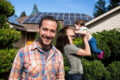 A family standing in front of a house with solar panels in Cairns.