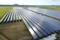 An aerial view of a solar farm with rows of solar panels, showcasing the impressive work by Hielscher Electrical.