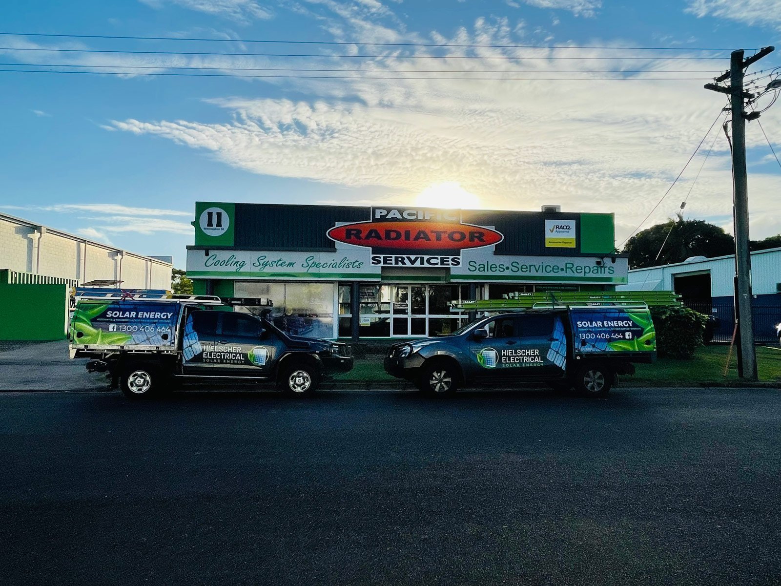 Two solar-powered vans parked in front of a building.