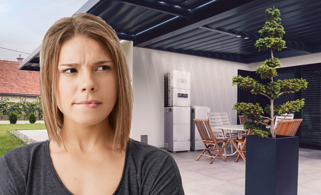 A woman standing in front of a house with solar panels.