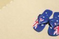 A pair of Australian flag flip flops on the sand in Cairns.