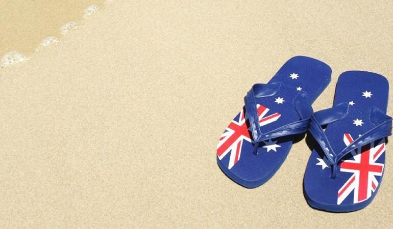A pair of Australian flag flip flops on the sand in Cairns.