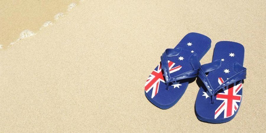 A pair of Australian flag flip flops on the sand in Cairns.