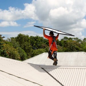 A man holding a solar surfboard on top of a roof, promoting Solar Power.