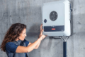 A woman is installing solar panels on a wall in Cairns.