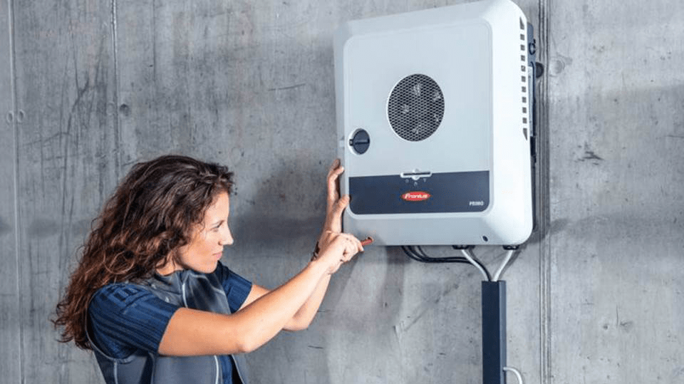 A woman is installing solar panels on a wall in Cairns.