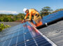 A worker from Hielscher Electrical is installing solar panels on a roof in Cairns.