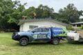 A Solar-powered truck is parked in front of a house.