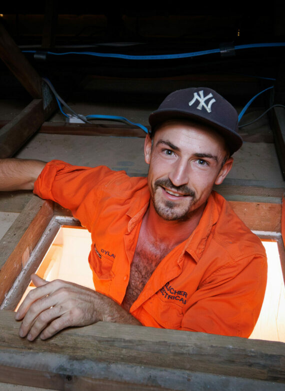 A man wearing an orange shirt installs Hielscher Electrical solar panels.