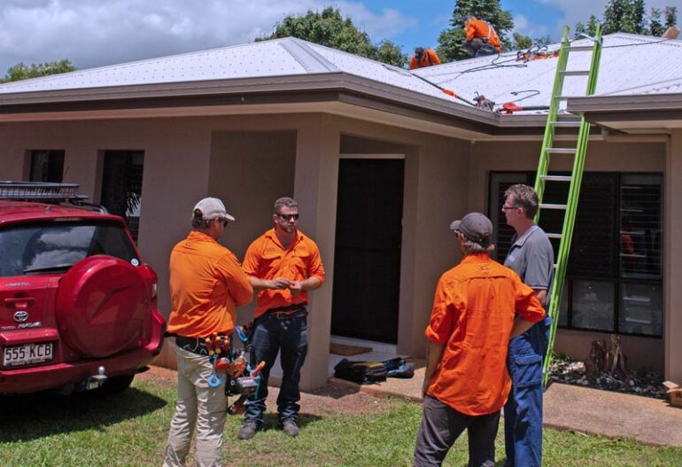 A group of men from Hielscher Electrical standing in front of a solar-powered house in Cairns.