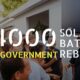 A group of people standing in front of a house with the words $4,000 solar battery qld government rebate and Solar Power.