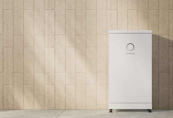 An 10kWh Sonnen Batterie Evo stands against a beige textured concrete wall in a well-lit space.