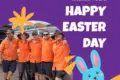 Five people in orange work shirts pose outdoors; text reads "Hielscher Electrical Wishes You a Happy Easter Day" with a cartoon blue bunny on a purple background. Celebrate Easter with Hielscher Electrical!.